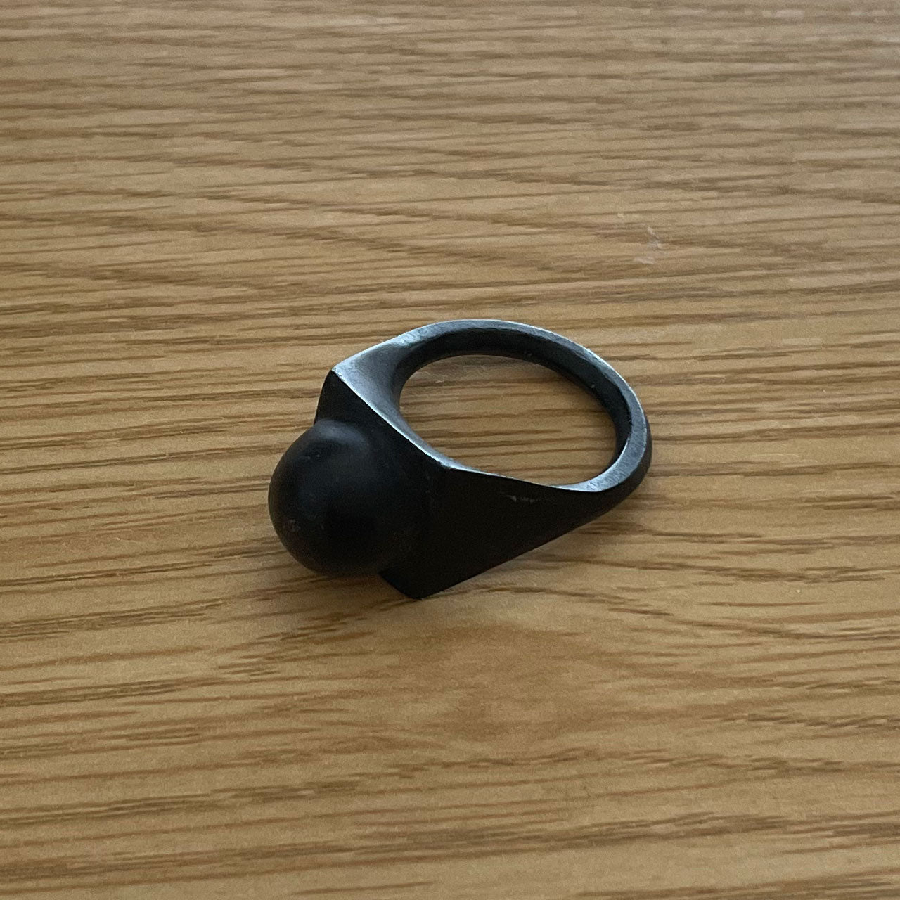 3D printer made (PLA) simple design ring (black) with circular protrusion at the tip