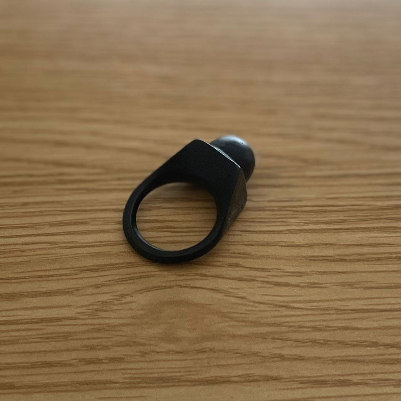 3D printer made (PLA) simple design ring (black) with circular protrusion at the tip