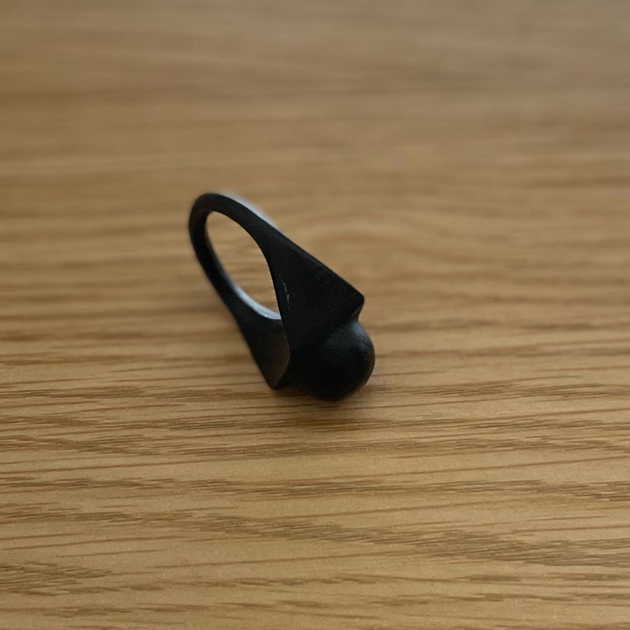 3D printer made (PLA) simple design ring (black) with circular protrusion at the tip