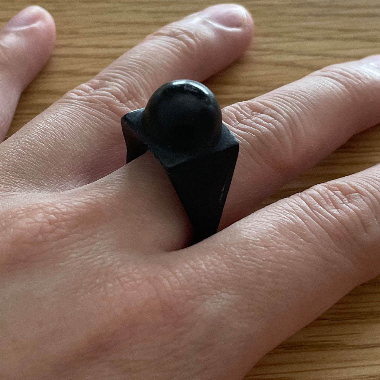 3D printer made (PLA) simple design ring (black) with circular protrusion at the tip